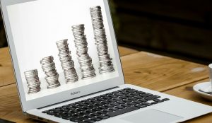 Accounting Firm picture on a laptop computer with stacks of coins getting gradually larger. 