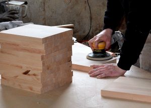 Trim Carpenter sanding wood for use on a job.